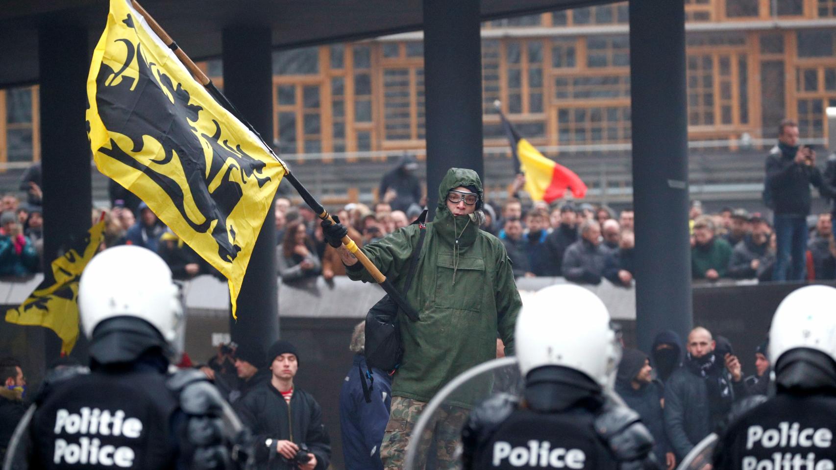 Nacionalistas flamencos enarbolan banderas de la región y de Bélgica en los incidentes de la marcha contra la inmigración en Bruselas.