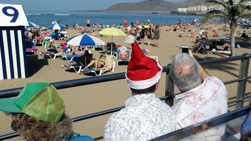 Numerosos turistas y vecinos de Las Palmas de Gran Canaria han disfrutado hoy de un día de Navidad al sol en la playa de Las Canteras.