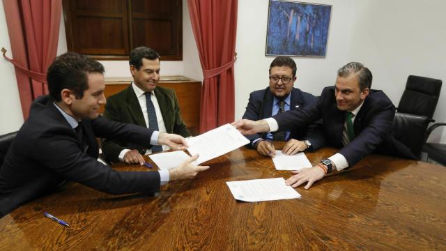 Teodoro García Egea y Javier Ortega Smith intercambian documentos para la firma ante Juanma Moreno y Francisco Serrano.