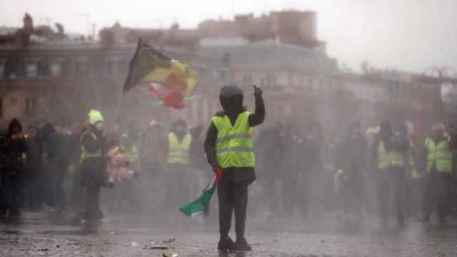 Un manifestante de los 'chaleco amarillos' se enfrenta a la Policía en las inmediaciones del Arco del Triunfo, en París.