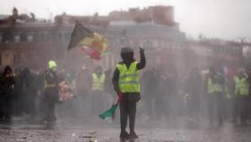 Un manifestante de los 'chaleco amarillos' se enfrenta a la Policía en las inmediaciones del Arco del Triunfo, en París.
