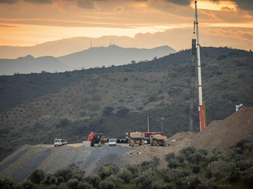 'Zona cero' del rescate de Julen. En la imagen aparece la perforadora, una grúa sosteniendo los 42 metros de tubos soldados y, en el centro, sobre una camioneta, la cápsula metálica en la que deben descender los mineros en busca de Julen.