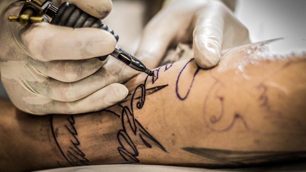 Realización de un tatuaje en el brazo.