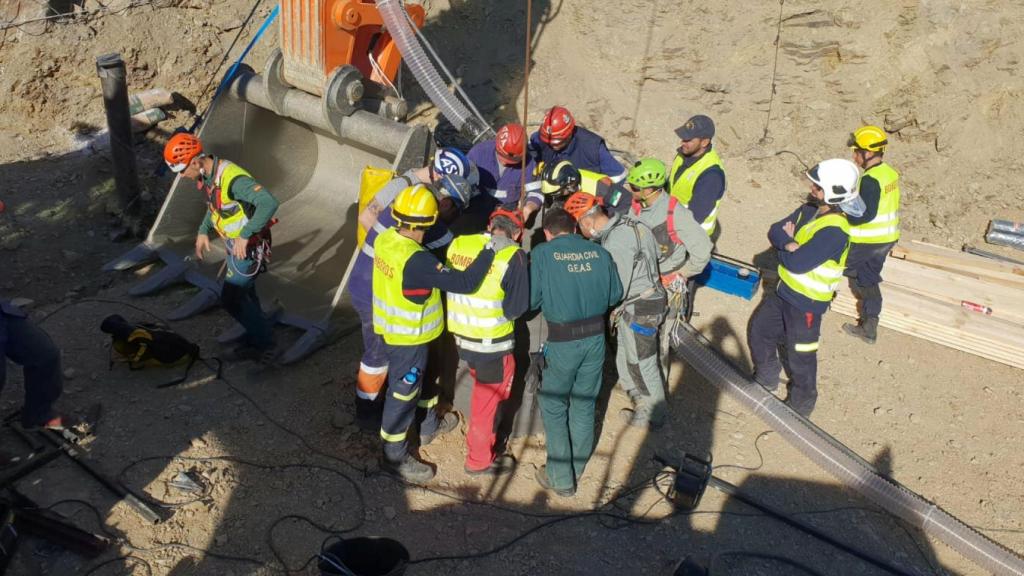 Mineros, especialistas y guardia civil miran el pozo por el que desciende la cápsula.