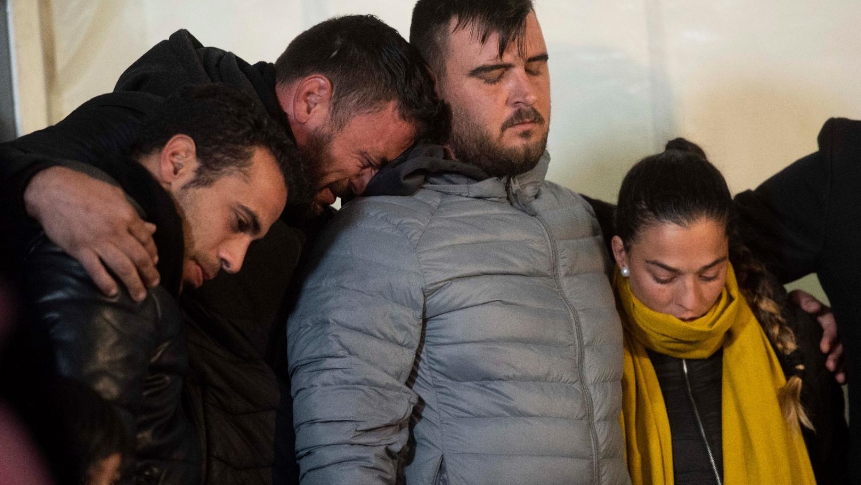 David, el dueño de la finca, apoya su cabeza sobre el padre de Julen, que viste un abrigo gris