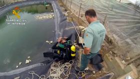 Agentes de la Guardia Civil preparándose para sumergirse en una balsa