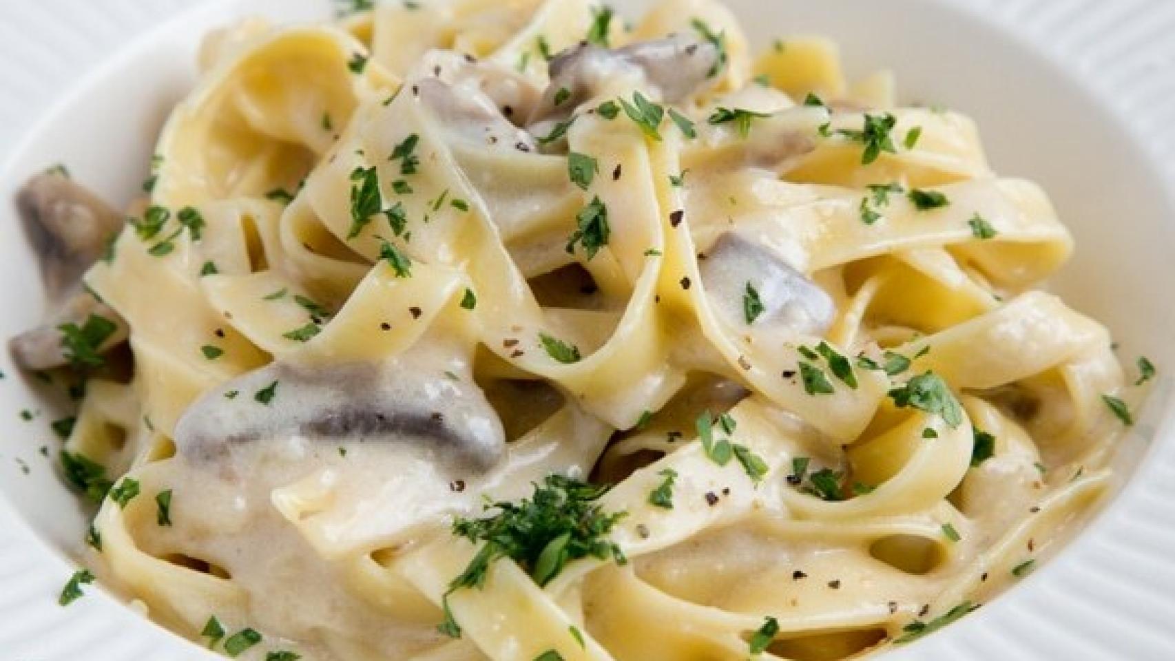 Un plato de Fettuccini Alfredo bien cargadito de nata y queso.