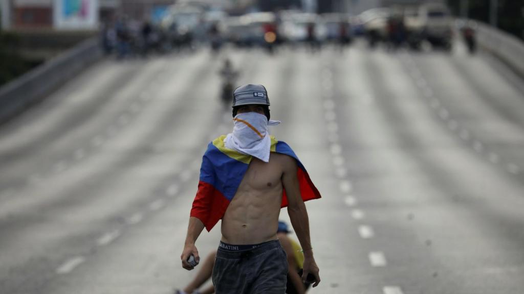 Un joven opositor, con una piedra en una manifestación en Caracas.