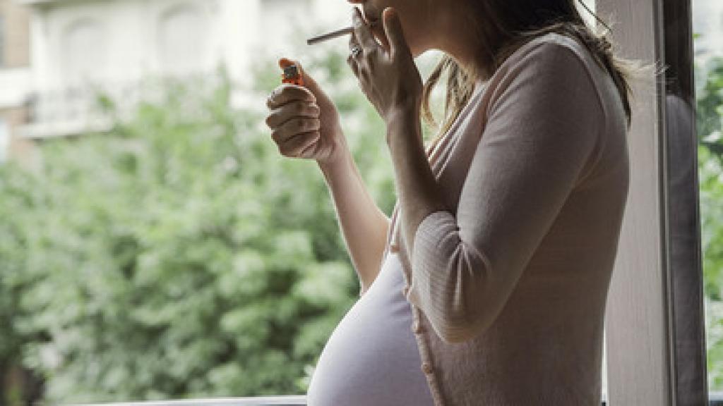 Una embarazada fumando.