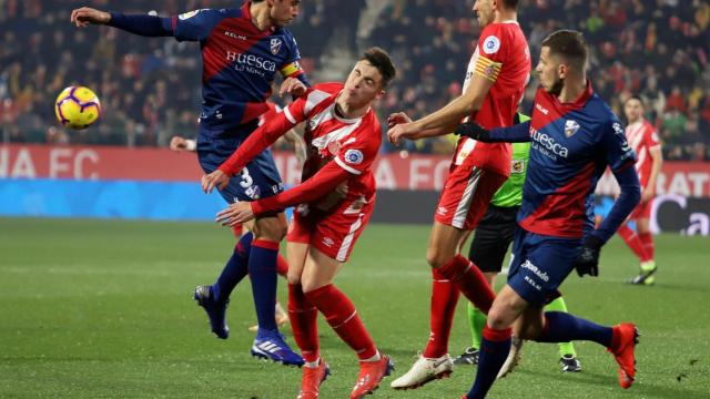 Valery Fernández lucha el balón con Etxeita durante el Girona - Huesca de La Liga