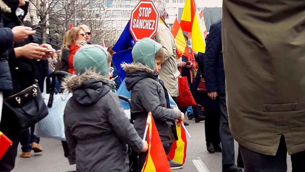 Unos niños con banderas de España, en medio de la concentración de Colón contra Pedro Sánchez.