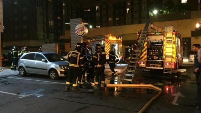 Los bomberos trabajan en el  Burger King de Usera que ha sido desalojado por un incendio.