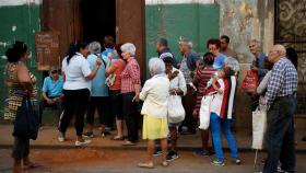 Cubanos haciendo cola frente a una bodega