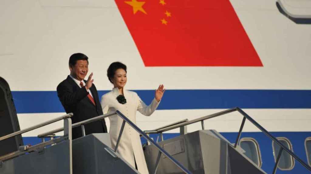 El presidente chino Xi Jinping junto a su esposa bajando de un avión.