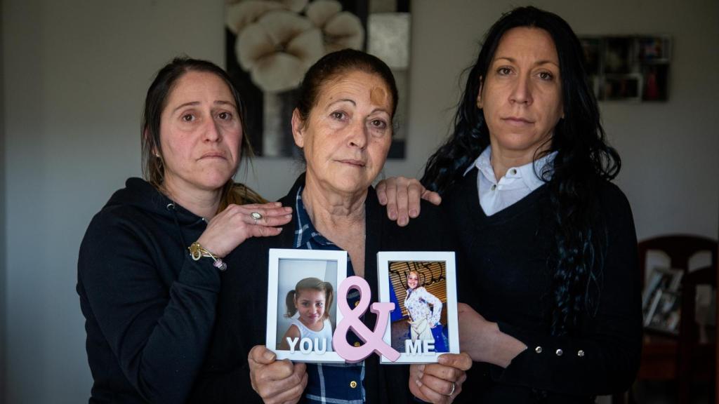 Josefa Capitán, junto a sus hijas Vanesa (d) y Susana (i), sostiene entre sus manos los retratos de su hija Sandra y su nieta Lucía, quienes fueron asesinadas junto a la pareja de Sandra y enterrados en el interior de un piso de Dos Hermanas.