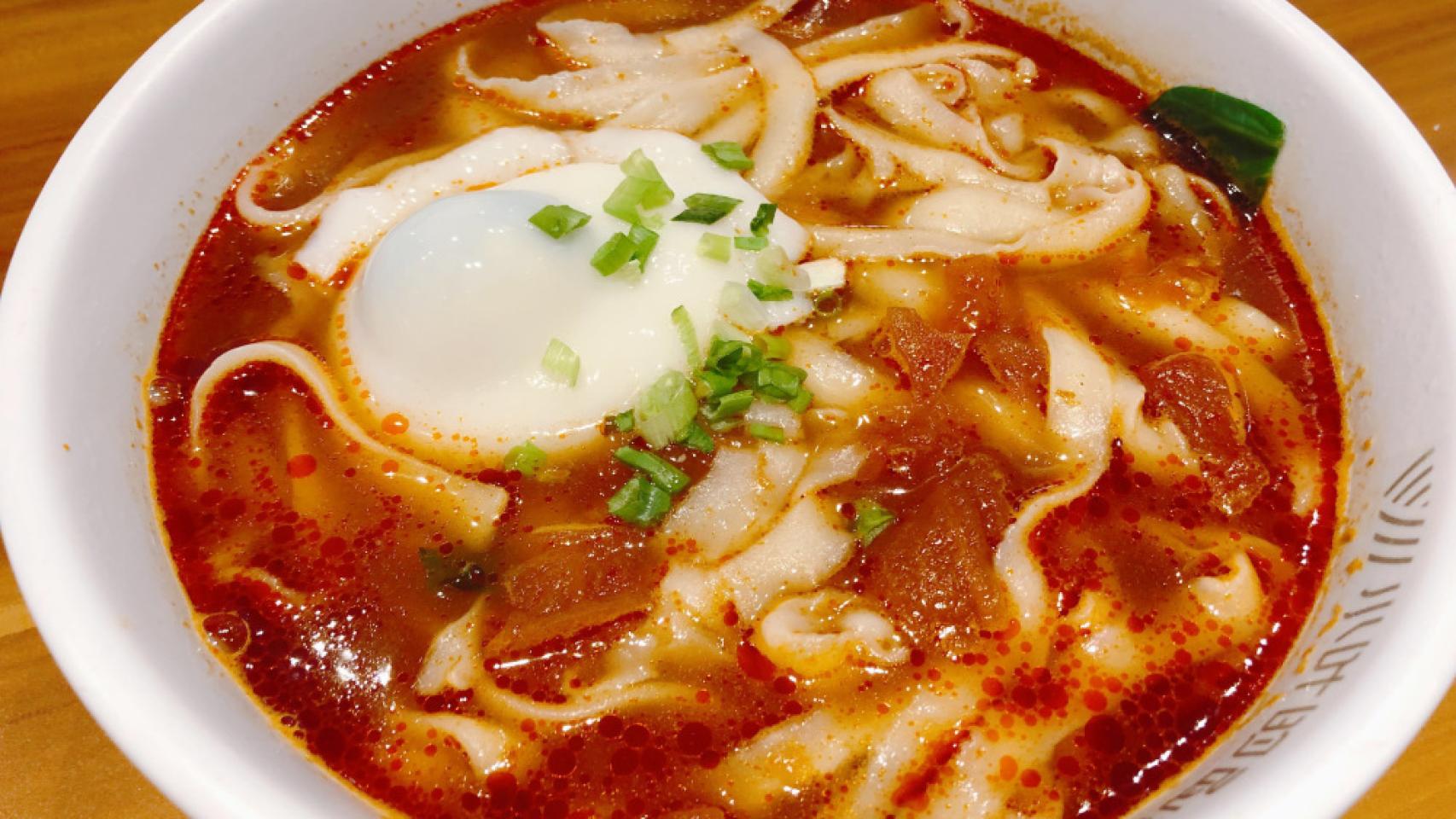 Una sopa de 'noodles' de huevo con tomate.