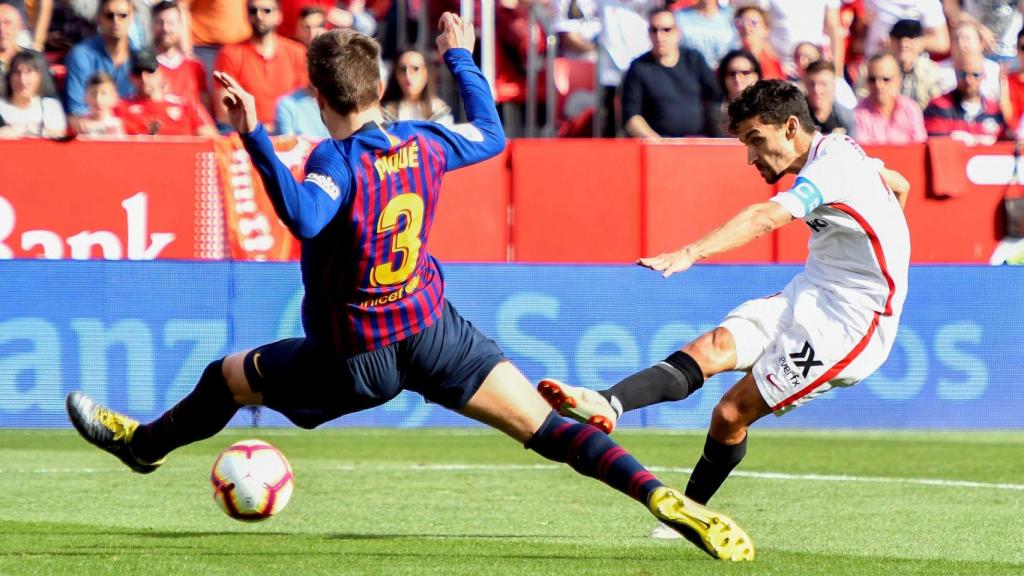 Jesús Navas dispara a puerta ante Piqué en el Sevilla - Barcelona de La Liga