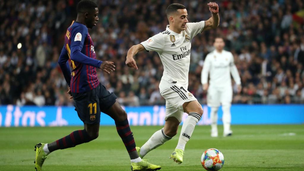 Dembelé intenta robar el balón a Lucas Vázquez