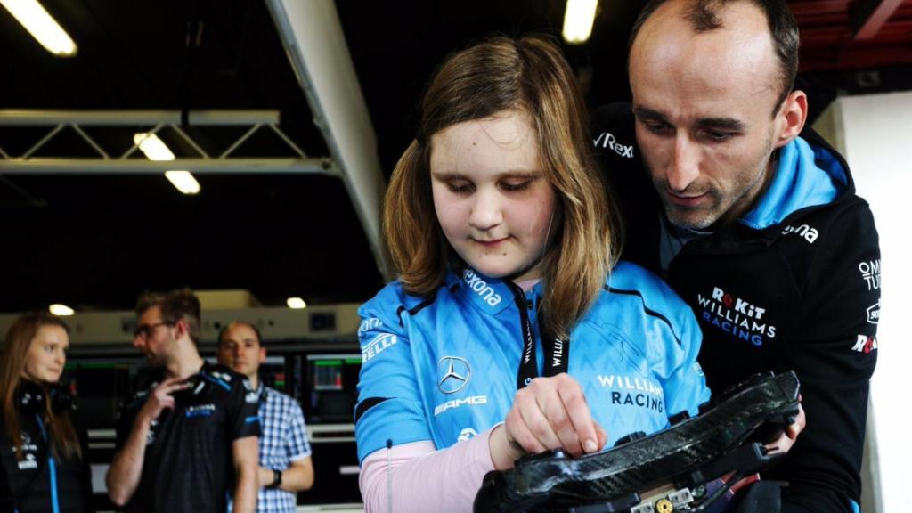 Kubica muestra mediante el tacto el coche a una niña ciega. Foto: Twitter. (@PKN_ORLEN)