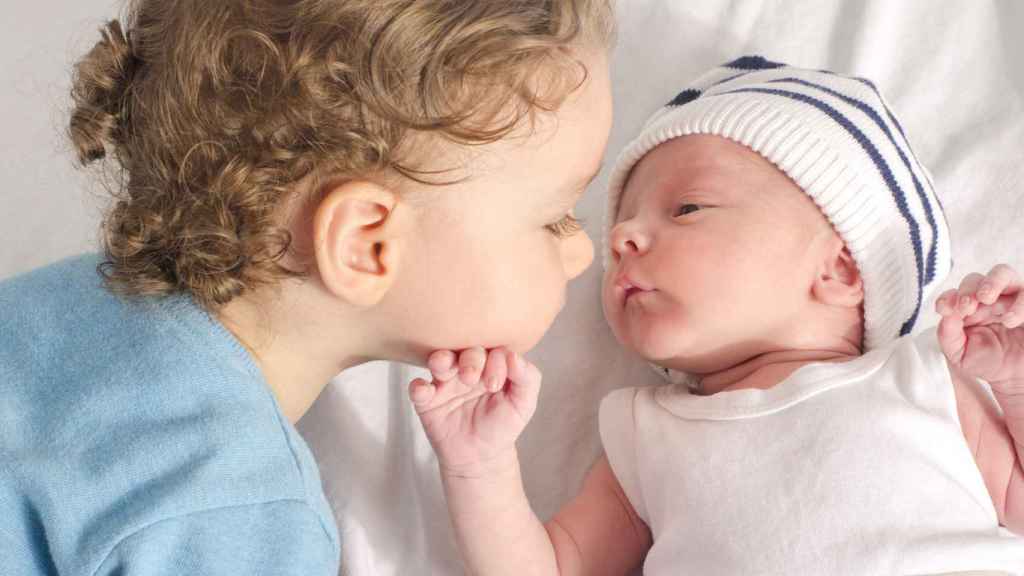 Un niño observa a su hermano menor recién nacido. Foto: luanateutzi