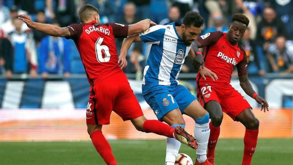 Borja Iglesias intenta llevarse el balón ante los jugadores del Sevilla