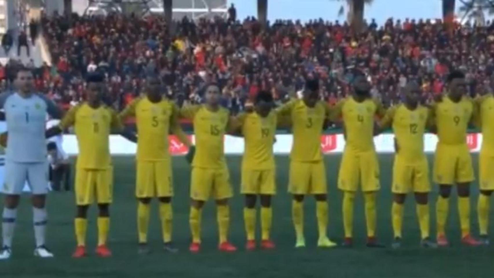 Los jugadores de la selección de Sudáfrica de fútbol escuchan su himno nacional previo al partido contra Libia