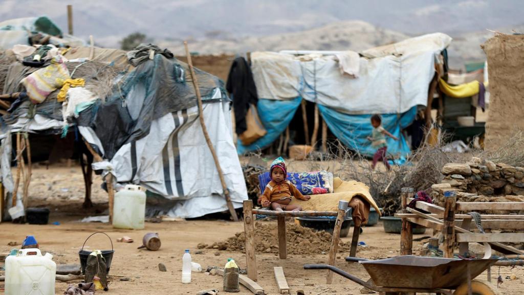 Un niño sentado sobre una cama improvisada en un campo de desplazados en Yemen.