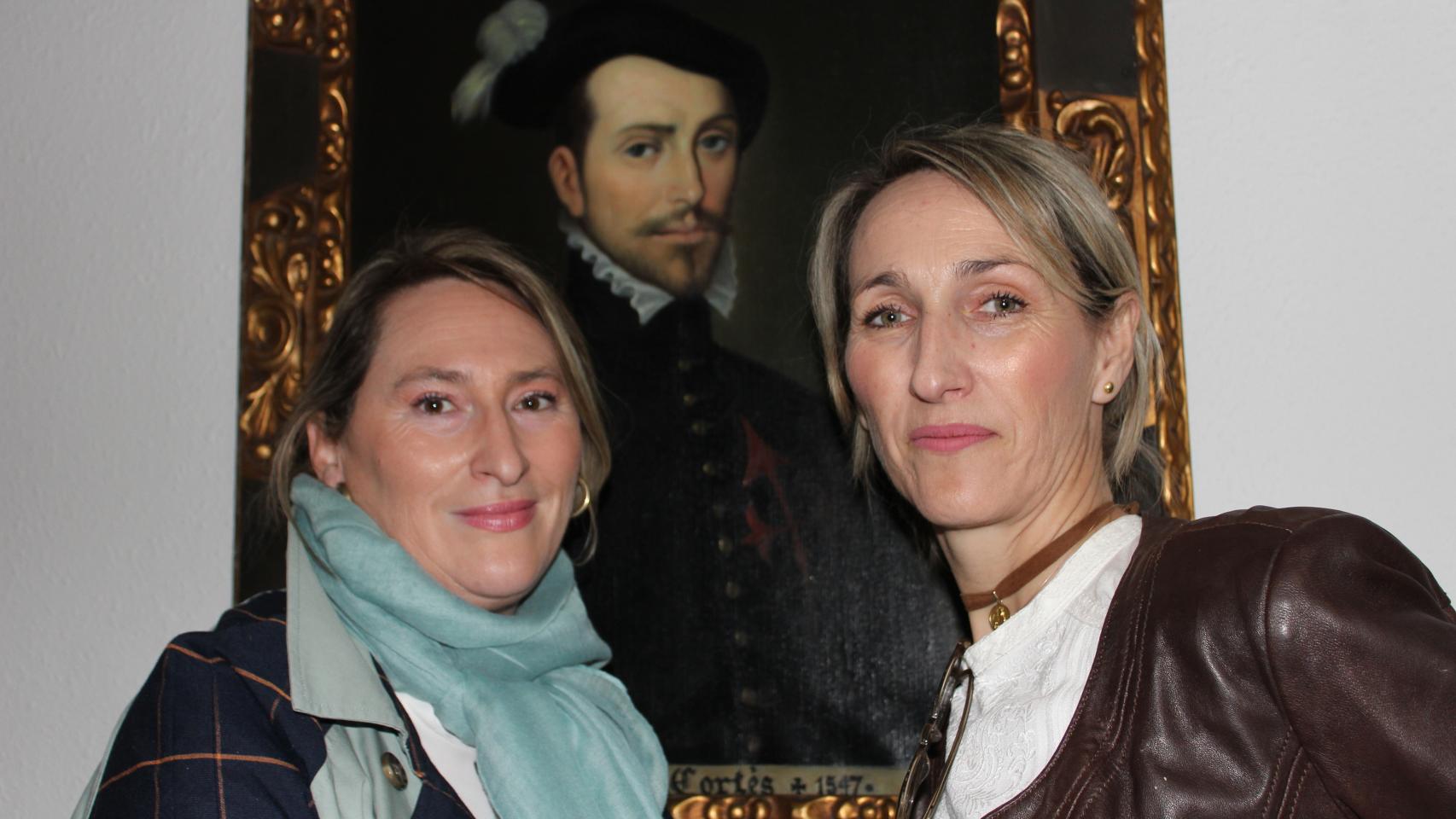 Susana Cortés y Virginia Cortés junto a su antepasado, en un retrato, el conquistador Hernán Cortés.