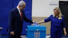 El primer ministro israelí, Benjamín Netanyahu, votando esta mañana junto a su mujer.