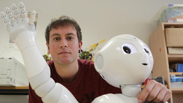 Igor Rodriguez, autor principal del trabajo, junto a un robot humanoide.