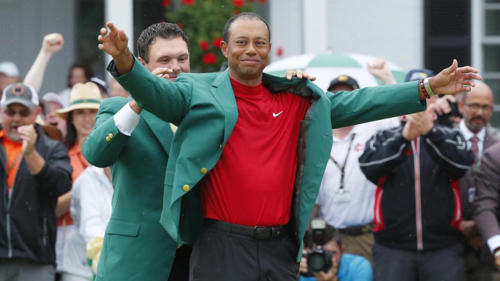 Patrick Reed, campeón de 2018, viste a Tiger Woods con la chaqueta verde de campeón del Masters 2019.