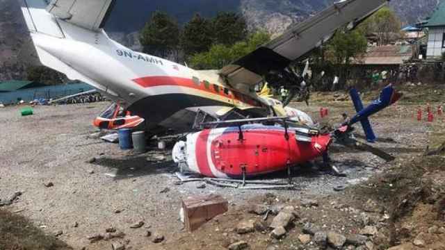 Restos del avión tras chocar contra dos helicópteros en el aeropuerto de Lukla (Nepal).