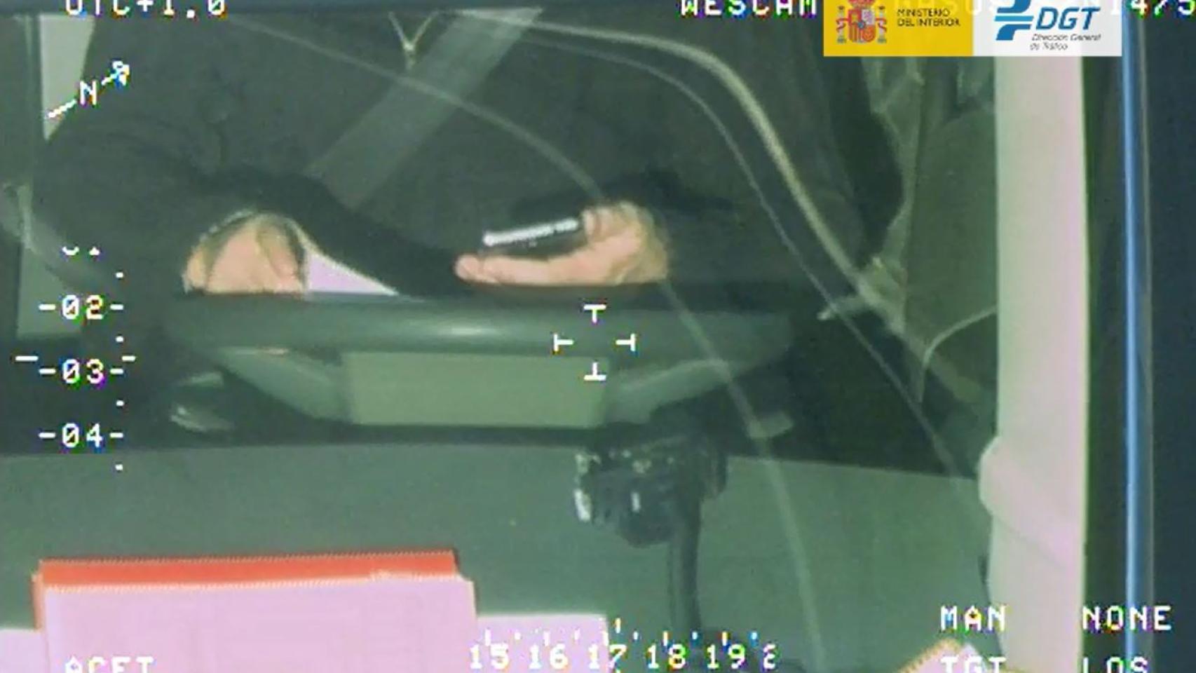 Imagen captada por la DGT de un conductor utilizando el móvil al volante.