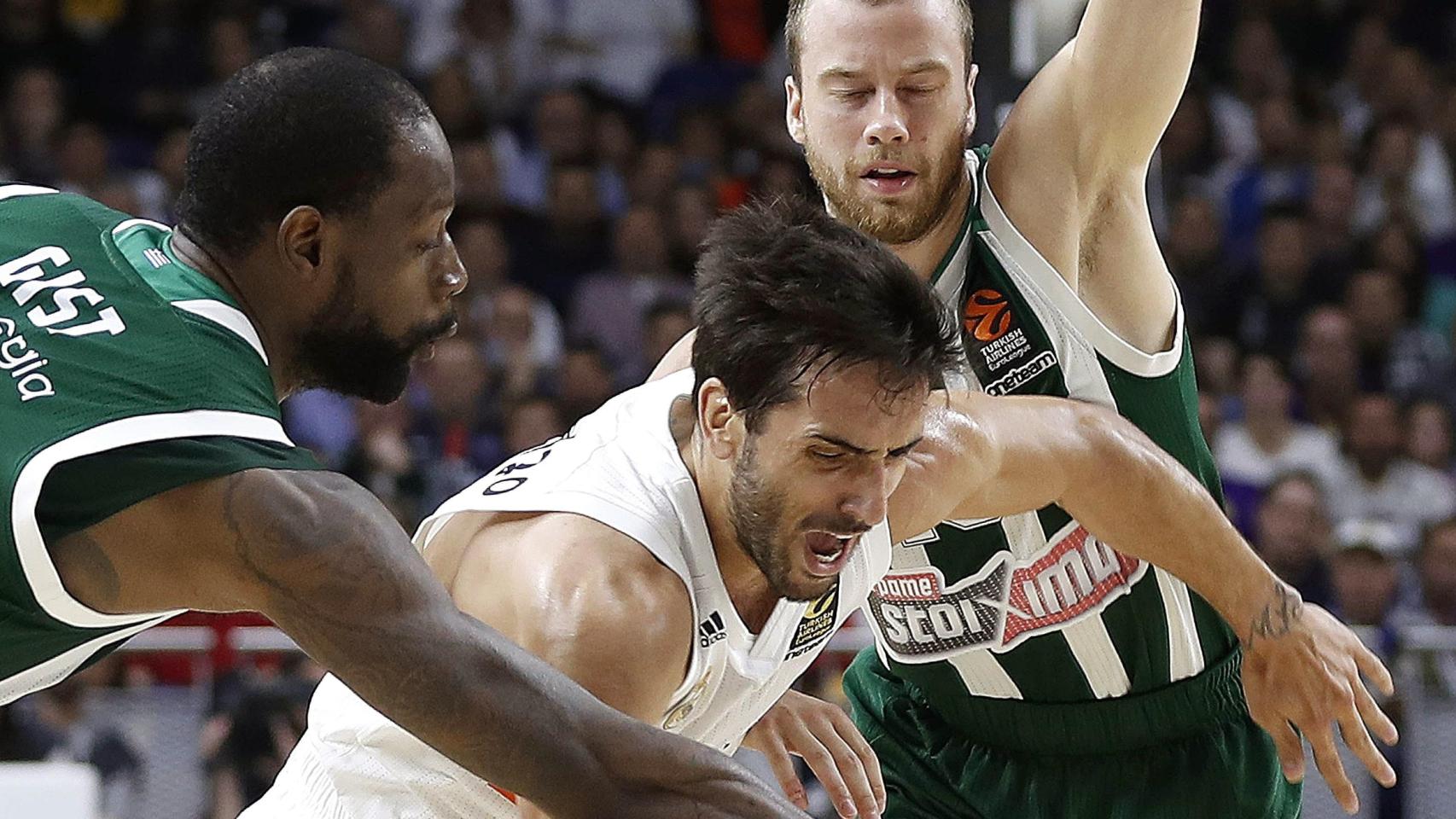 Campazzo intenta liberarse de dos defensores en el primer choque de los playoffs