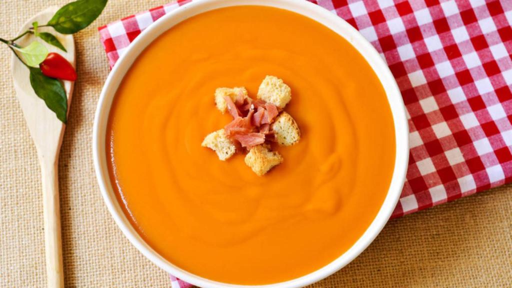 Un plato de salmorejo, con jamón y picatostes.