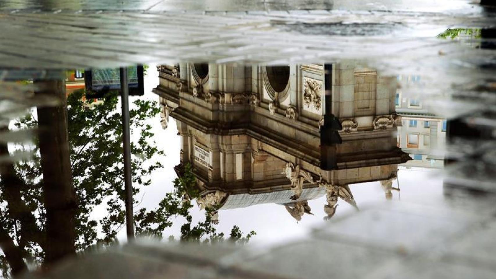 La Puerta de Alcalá reflejada en un charco en Madrid / EFE / Carlos Pérez.