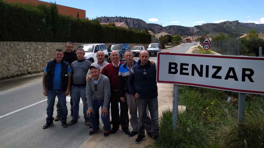 El alcalde pedáneo de Benizar junto al cartel del pueblo y varios vecinos.