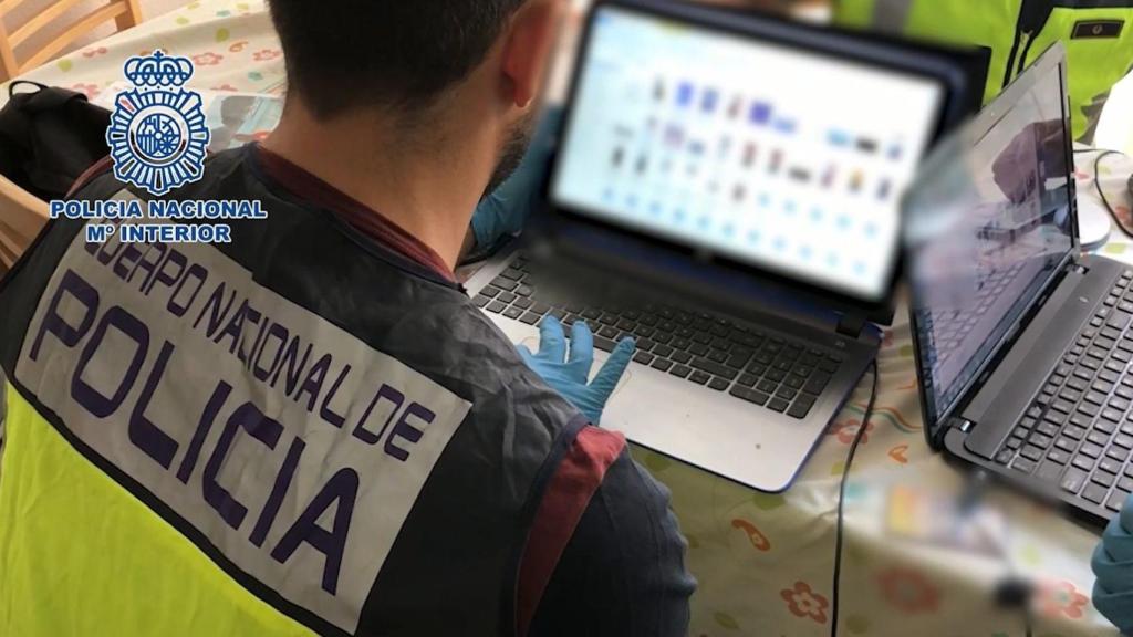 Un agente de Policía Nacional inspecciona un ordenador en una operación contra la pederastia.