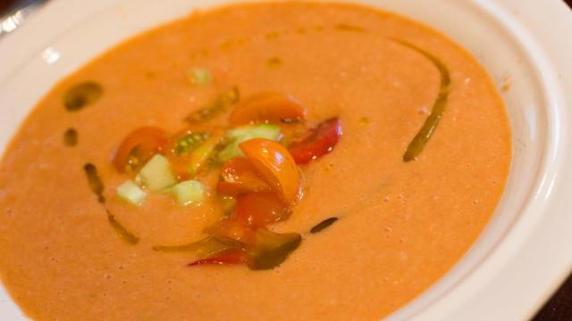 Un plato de gazpacho con tomate, aceite de oliva y pepino.