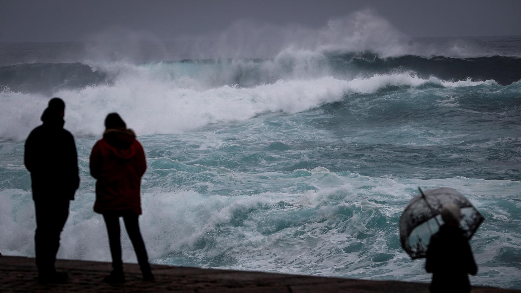 Varias personas observan el mar este sábado en San Sebastián. EFE/Javier Etxezarreta.