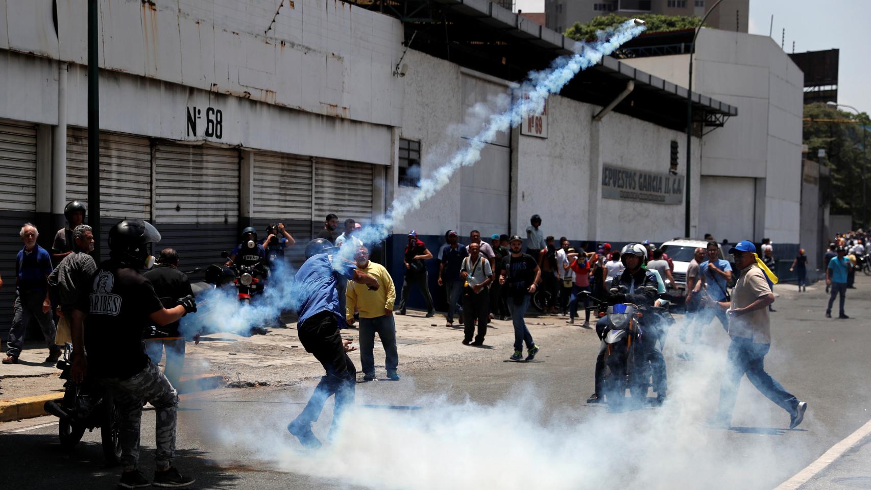 Opositores lanzan objetos a los militares chavistas.