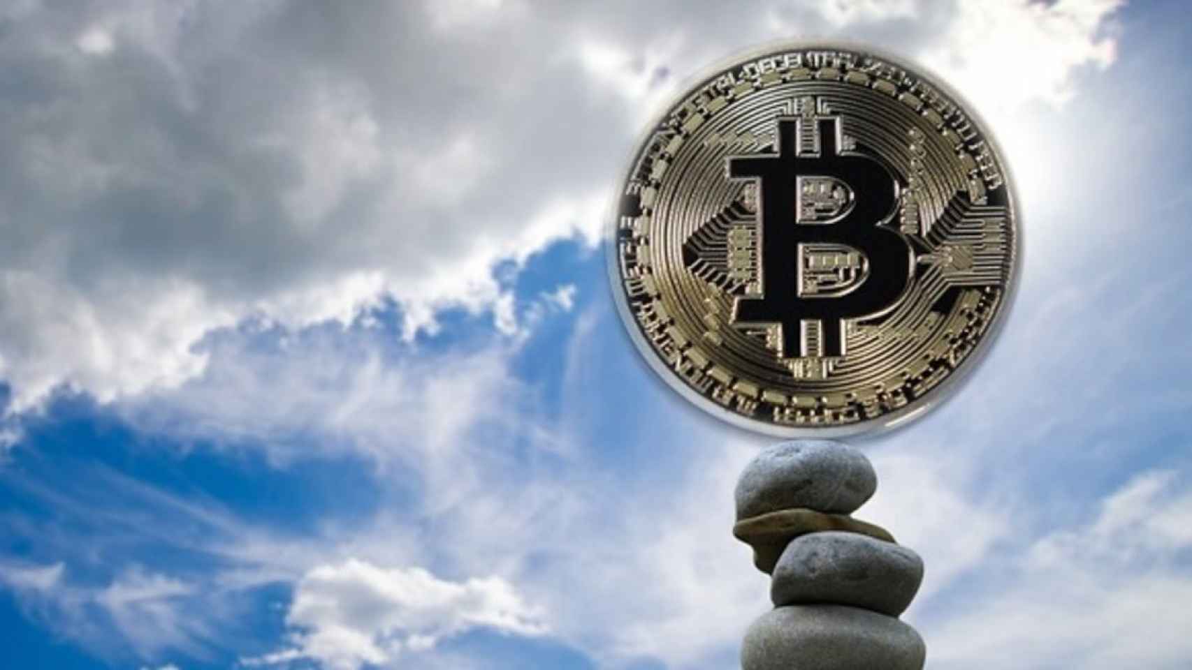 Una moneda física de bitcoin apuntando al alza.