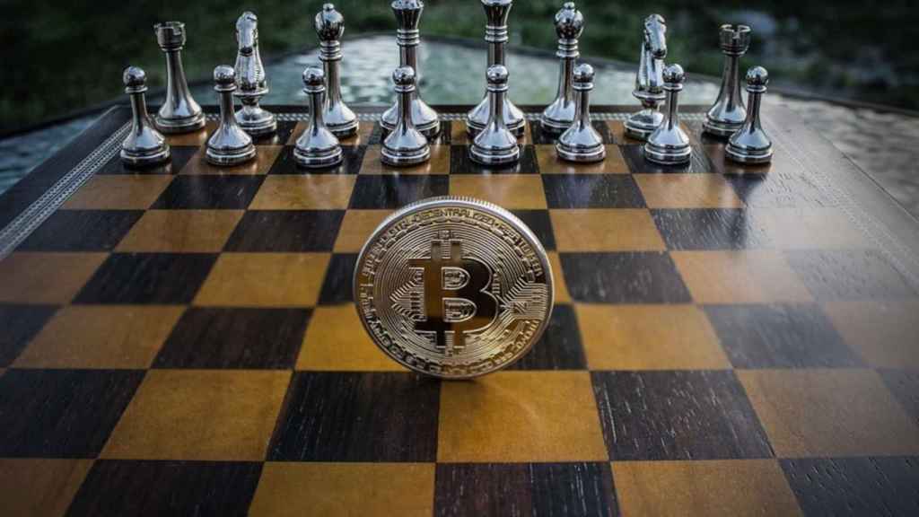 Una moneda de bitcoin en un tablero de ajedrez.
