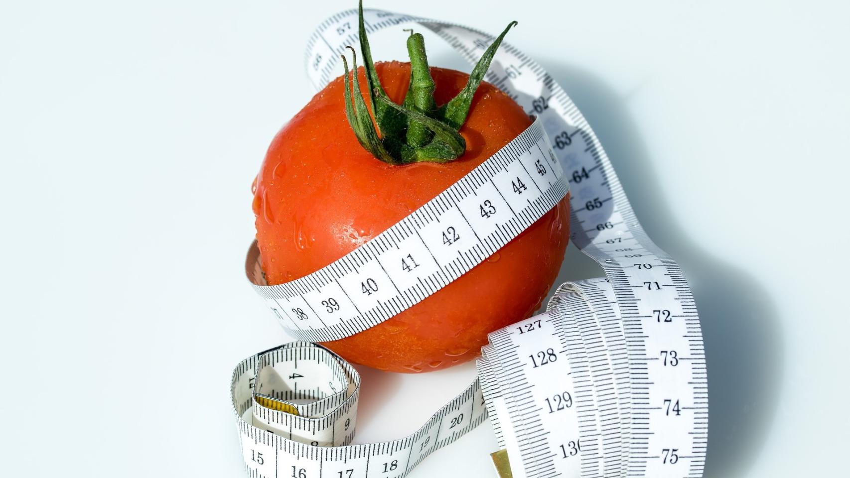 Una cinta métrica rodeando un tomate.