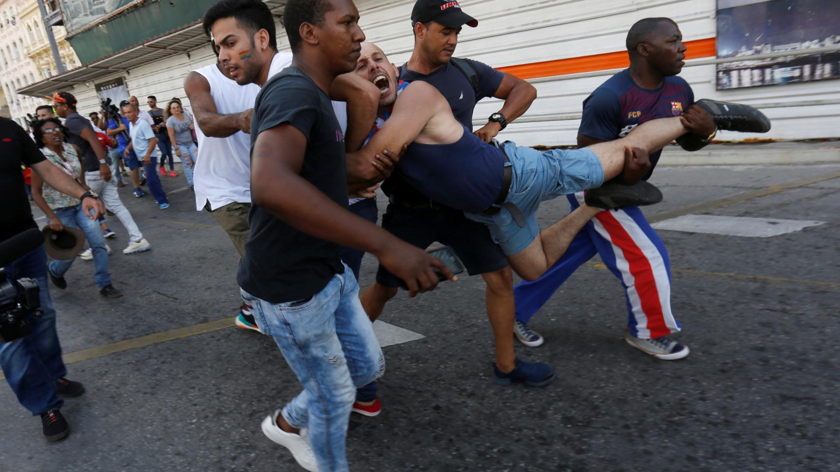 Un hombre es llevado en volandas por fuerzas de seguridad de Cuba