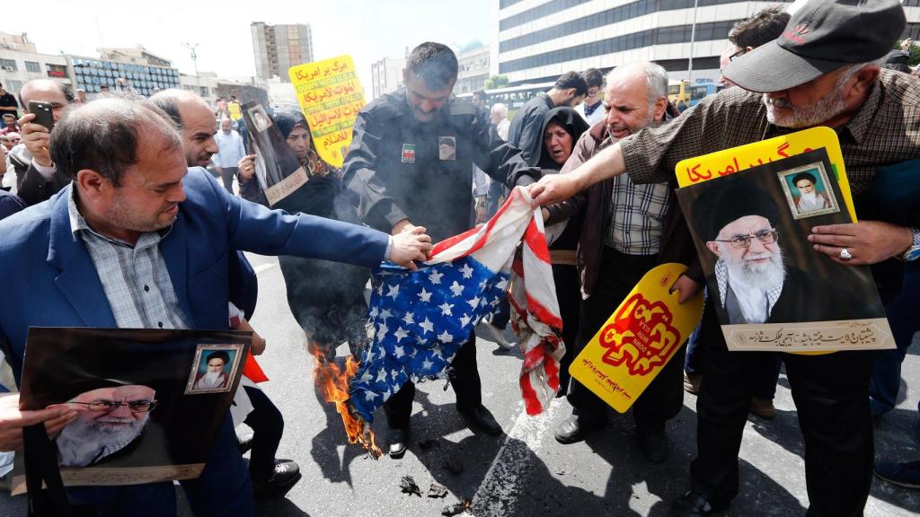 Manifestantes iraníes queman una bandera de EEUU en una protesta contra la administración Trump.