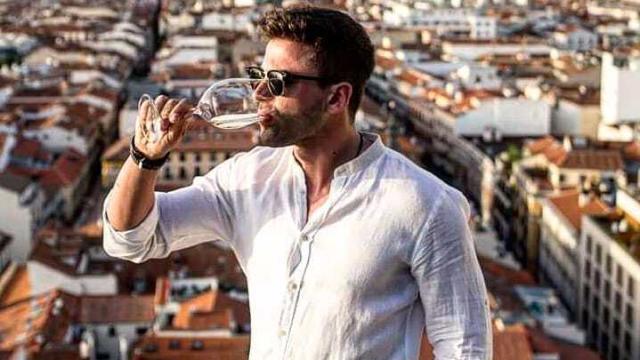 Sergio Ayala tomando una copa de vino blanco de la bodega donde trabaja.