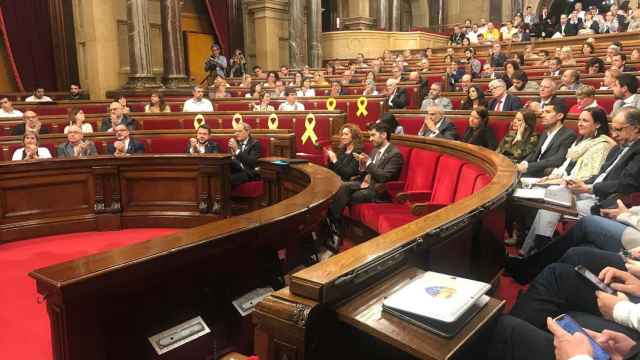 Imagen del Parlament con los lazos amarillos en los escaños vacíos