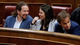 El líder de Podemos, Pablo Iglesias, habla con Irene Montero en sus escaños.
