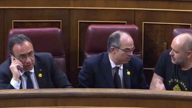 Josep Rull hablando con Carles Puigdemont desde su escaño.